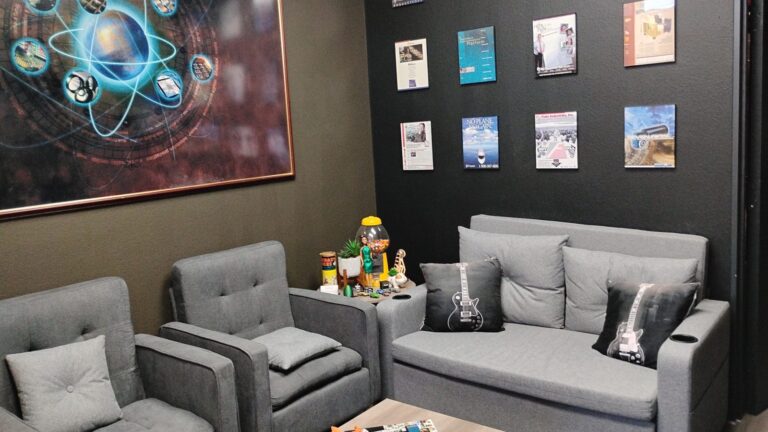 Client lounge with sofa, armchairs and framed art