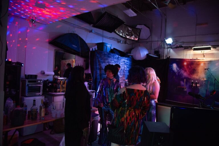 Guests in the studio under colorful stage lighting