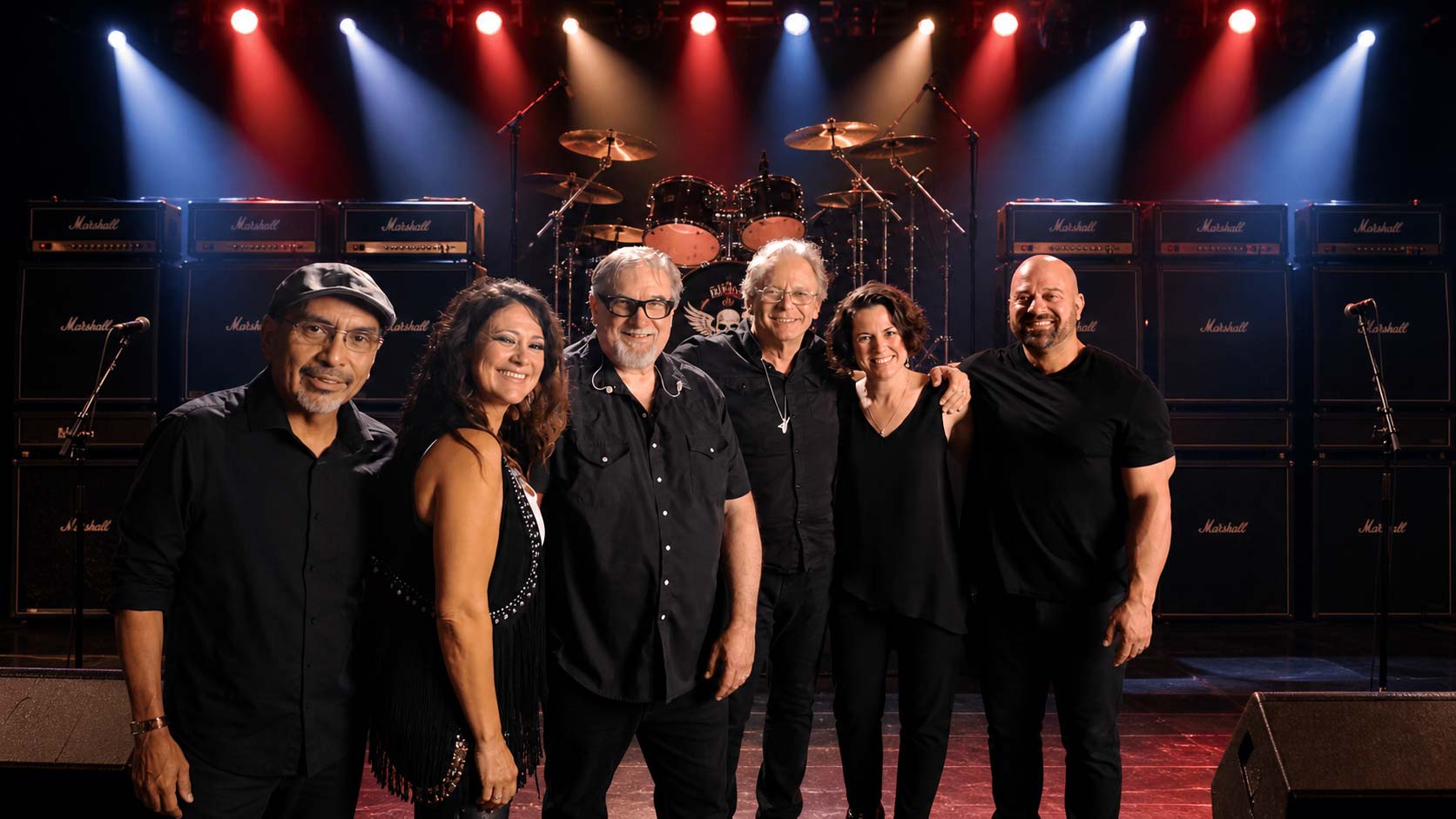 Band posing together on a lit concert stage